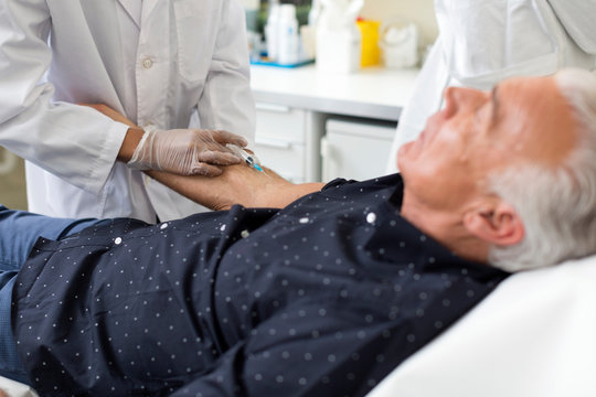 Doctor Extracting Patient's Blood With Syringe