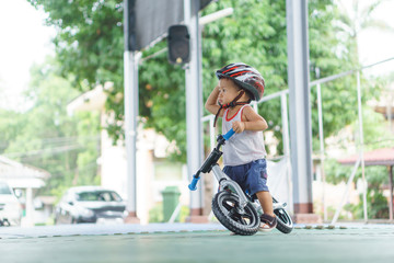 Obraz premium Asian boy is playing with baby balance bike