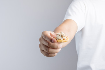 Hand holding instant tuna spread biscuit from convenience store