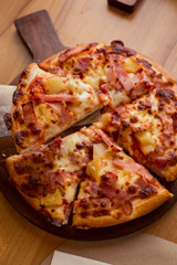 Hawaiian Pizza on wooden table.