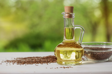 flax seeds and linseed oil in a glass jug on a wooden table