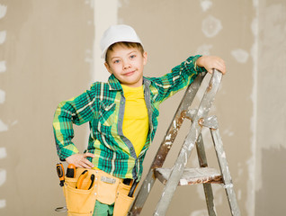 Portrait of a happy child on a ladder with tools