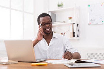 Obraz premium Young black businessman call mobile phone in modern white office