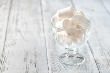 Obraz na płótnie Canvas Glass bowl of marshmallows on the wooden background