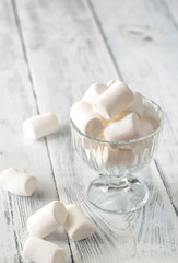 Glass bowl of marshmallows on the wooden background