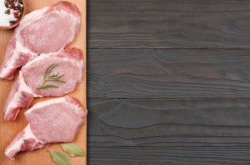 fresh raw meat with spices on wooden table. top view with copy space