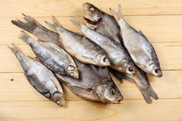 Dried fish on the table. Salty dry river fish on a light wooden background.top view with copy space