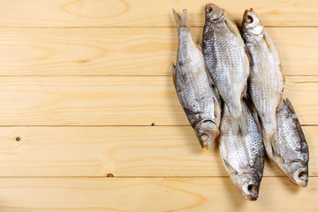 Dried fish on the table. Salty dry river fish on a light wooden background.top view with copy space