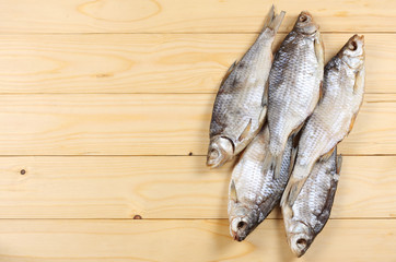 Dried fish on the table. Salty dry river fish on a light wooden background.top view with copy space