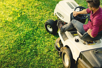 Top view of man using lawn mower for cutting grass, portrait of healthy lifestyle and weekends