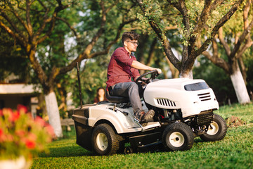 Professional gardner using lawn mower and cutting grass
