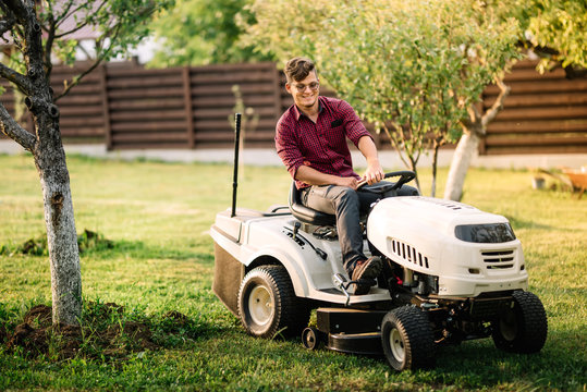 male worker using lawmower for landscaping works. Motorised agriculture concept