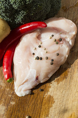 Raw chicken breast, fillets, broccoli, potatoes, chili, and pepper -  Ingredients for dinner preparation