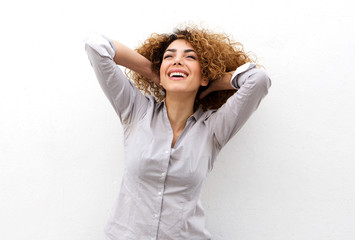 beautiful young woman laughing with hand in hair and looking up