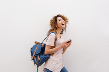 happy young woman walking with bag and cellphone