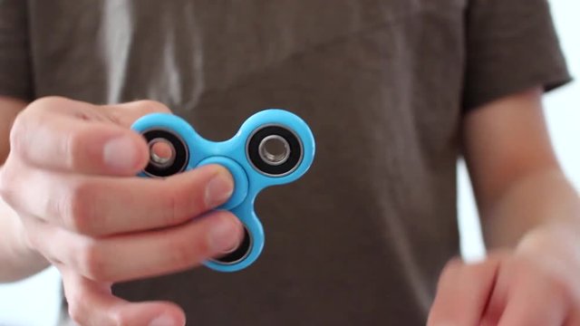 A guy showing his fidget spinner and playing with it