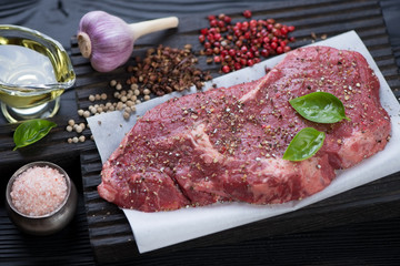 Close-up of fresh seasoned ribeye steak ready to be cooked, selective focus