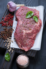 Raw fresh seasoned ribeye beefsteak, close-up, selective focus, studio shot