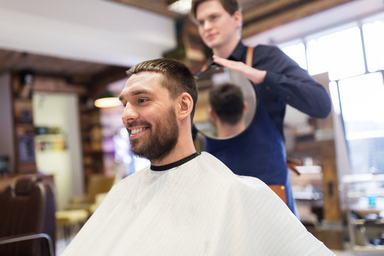 man and hairdresser with mirror at barbershop