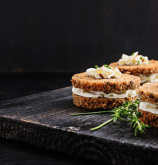 Sandwiches rye bread with cream cheese and mix seeds on a beige marble table  . Health snacks concept. Top view. Copy space.