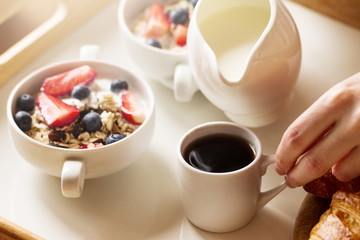 Tasty colorful Breakfast with Oatmeal, Yogurt, Strawberry, Blueberry, Honey and Milk on White Background. Breakfast in Bed. Closeup.