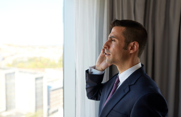 businessman calling on smartphone at hotel room