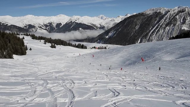 Skiers skiing on a fresh powder snow ski slope piste in alpine winter resort