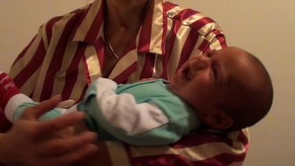 Mother manages to calm her crying baby, white background