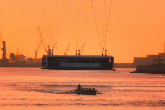 Hanging bridge and oarsmen at sunset