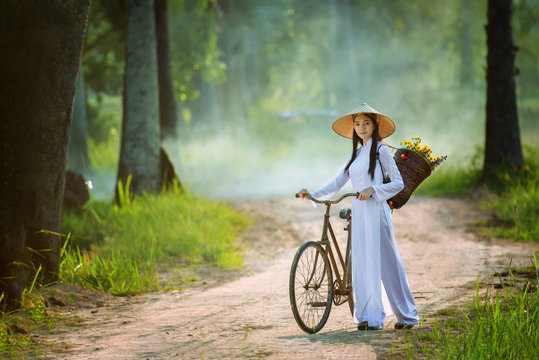 beautiful woman with Vietnam culture traditional dress, Ao dai and riding bicycle