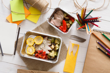 Healthy food in foil box on working table, diet concept.