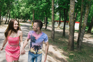 Young couple hugging and smiling each other walking on a bridge