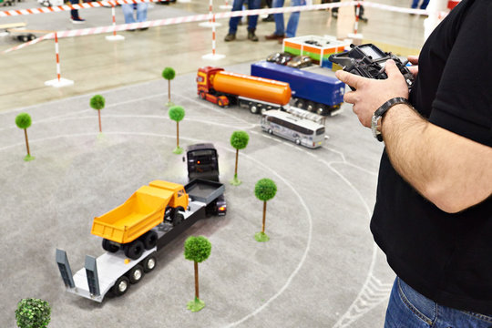 Man with radio remote control and truck model