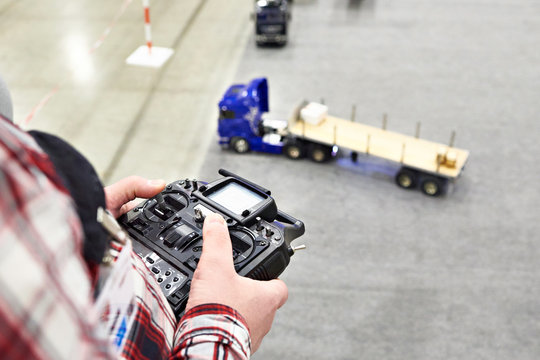 Man with radio remote control and truck model
