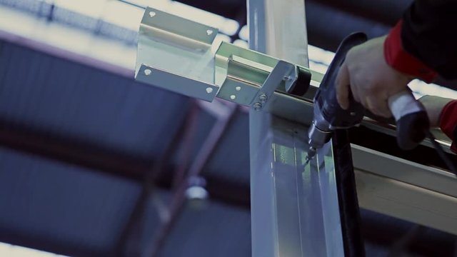 Man using an electric hand drill.