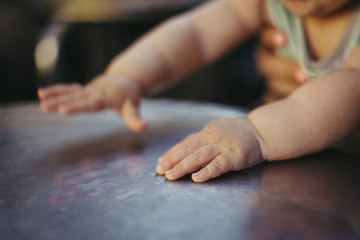 Fototapeta na wymiar Baby hands playing on a grey table