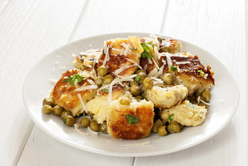 Potato gnocchi in a plate on a white table