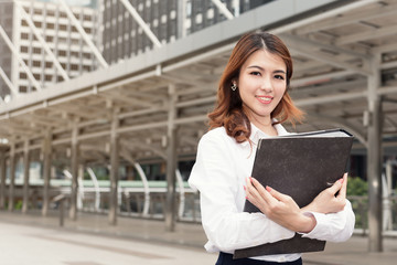 portrait of beautiful businesswoman with folder document at outdoors