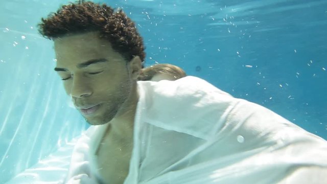 Two men sensually touch underwater