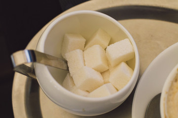 A cup of cappuccino with sugar in a modern cafe