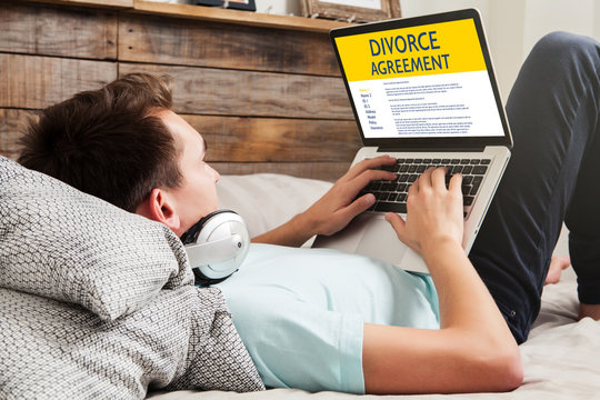 Divorce Agreement concept: Laptop computer with Divorce Agreement in the screen. Man using a laptop to read divorce agreement.
