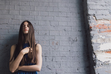 A very beautiful and cheerful girl stands on the street with long, luxurious hair
