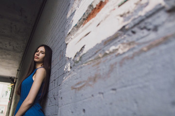 A very beautiful and cheerful girl stands on the street with long, luxurious hair