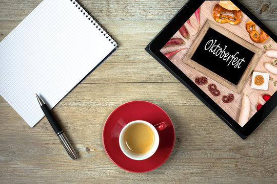 Notizblock mit Kugelschreiber mit Tablet mit Bild vom Oktoberfest - Powered by Adobe