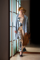Elegant beautiful blonde woman posing in studio, wearing fashionable dress