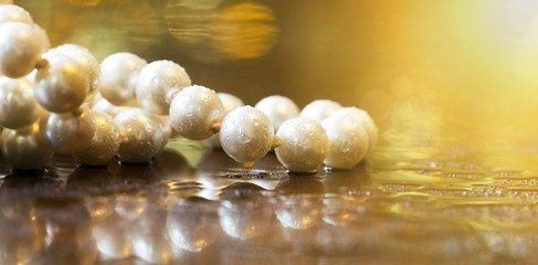 Website banner of beautiful white pearls on golden shiny background