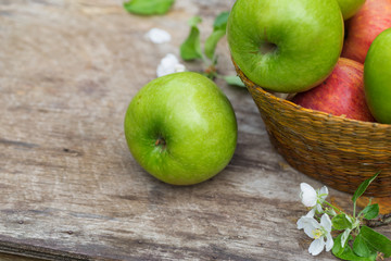 Fresh sweet juicy red green apples flowers on wood