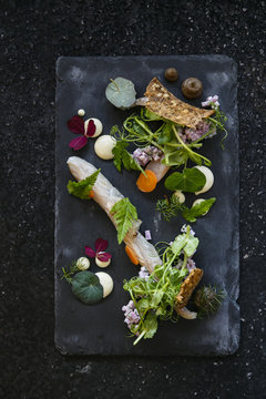 Mackrel with various vegetables on black slate