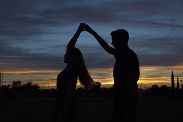 Woman and man dancing in the sunset