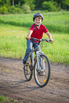boy ride on bike on rural road